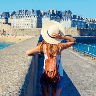 Hôtel à Saint-Malo Vue Mer 6 Jeune femme de dos caché sous son chapeau d'été qui admire intra-muros